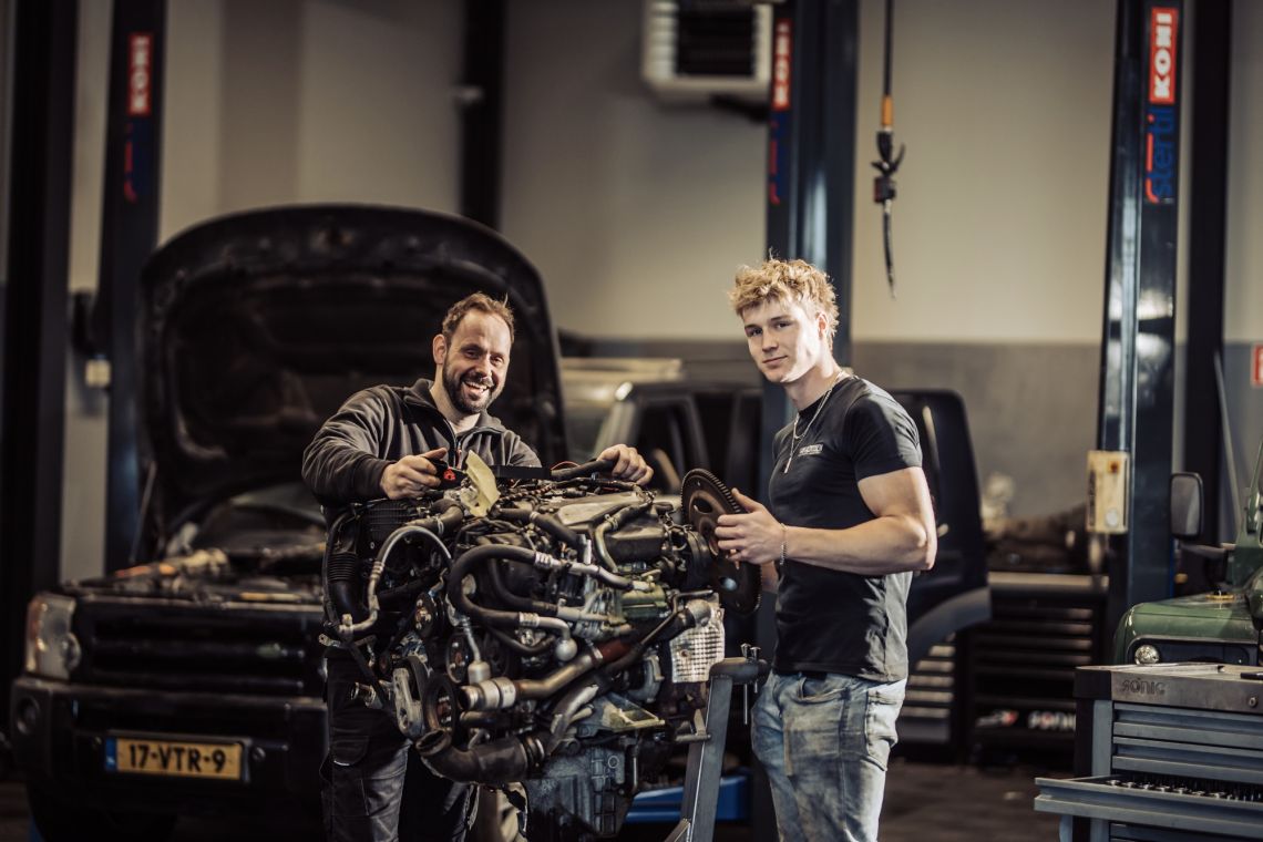 Land Rover monteurs staan bij uitgebouwde motor